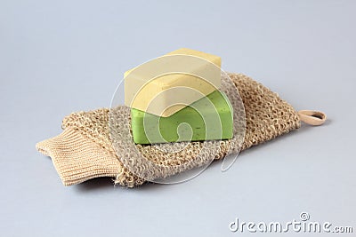 Close-up body washcloth made of natural fibers and two natural soaps on a blue background Stock Photo
