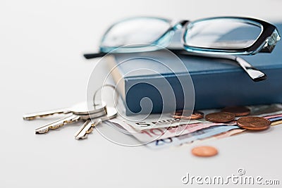 Close up of book, money, glasses and keys on table Stock Photo