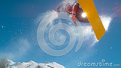 CLOSE UP: Athletic young male snowboarding spins in the air while doing a grab. Stock Photo