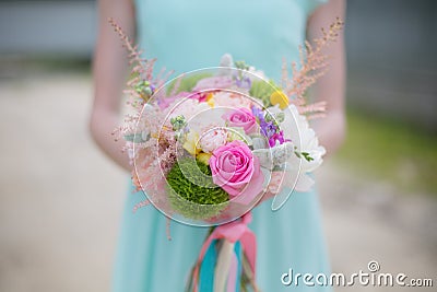Close-up of bouquet in hands of a girl in mint dress Stock Photo