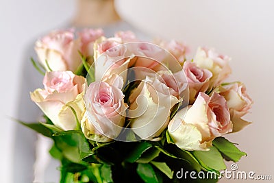 Close-up of bouquet of white, pink roses in hands of young man, brought flowers on date with girlfriend, gives to mom, concept of Stock Photo