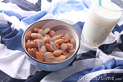 Close up of a bowl of almond nuts and milk on table cloth Stock Photo