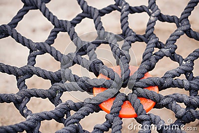 Close-up of braided rope mesh with orange ring in the middle Stock Photo
