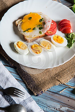 Close up of breakfast ingredients fried egg with bacon and pieces of boiled eggs Stock Photo