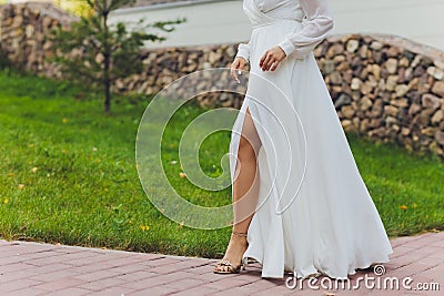 Close-up of a bride dancing in the street. Body part. Woman with bright dress dancing in the street Legs. Woman`s legs Stock Photo