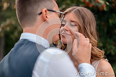 Close up Of Bride Face And Groom Hand Touching Her Face With Tender. Wife Looking AT Husband With Love and Adoration Stock Photo