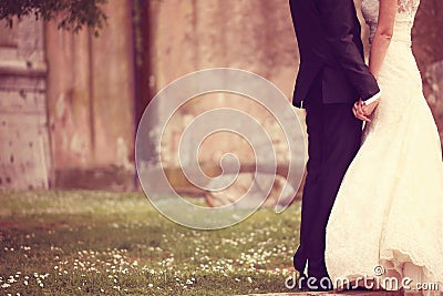 Close up of a bride and groom holding hands Stock Photo