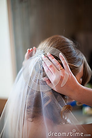Close up bride straightens her hair with a veil, back view Stock Photo