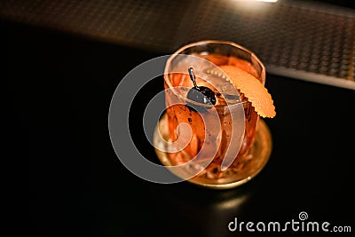 close-up on bright cold alcoholic drink in old-fashioned glass decorated with olive stands on table Stock Photo