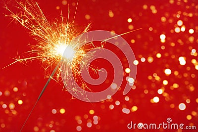 Close up of Brightly burning sparkler on a pink background with lots of sparks. Happy New Year concept Stock Photo
