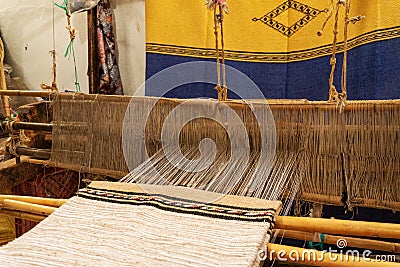 Close up of brocade fabric weaving on loom, cotton on the manual wood loom in Ouarzazate, Morocco Stock Photo