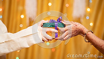 Close up of Brother Hands Giving gift to sister during during raksha Bandhan, Bhai Dooj or Bhaubeej Indian religious festival Stock Photo