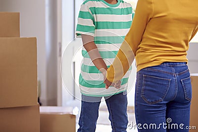 Close Up Of Brother And Sister Holding Hands Standing In Hallway Of New Home Stock Photo