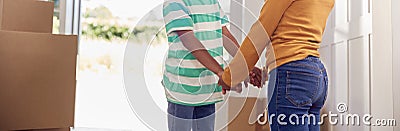 Close Up Of Brother And Sister Holding Hands Standing In Hallway Of New Home Stock Photo