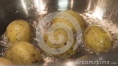 Close up for brown potatoes simmering in boiling water in the saucepan, food and cooking vegetables concept. Action Stock Photo