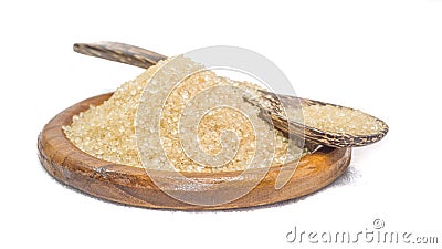 Close-up of brown sugar in a flat bowl and wooden spoon. White background. Isolated Stock Photo