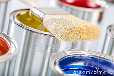 Close-up brush lying on multicolored paint cans Stock Photo