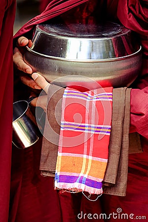 Close up of buddhist monk hands holding a bowl and cup Stock Photo