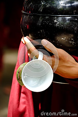 Close up of buddhist monk hands holding a vintage bowl and cup Stock Photo