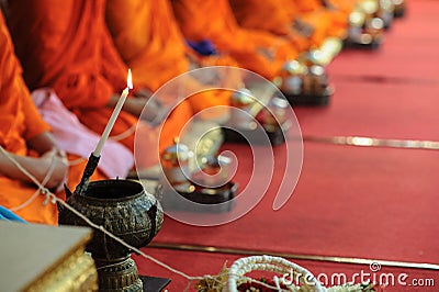 Close up of Buddhist monk prepare to pouring melt candle tears to the water for making blessing water Stock Photo