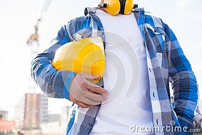 Close up of builder holding hardhat on building Stock Photo