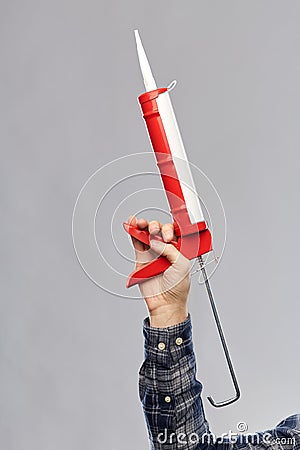 Close up of builder`s hand holding sealant gun Stock Photo