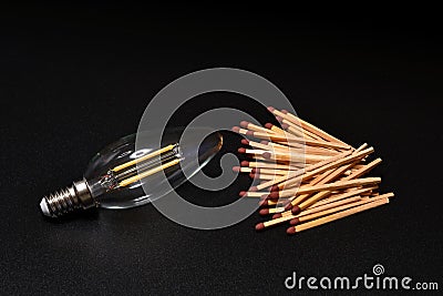 Close-up on a bulb light with matches on a black background. electricity supply problem concept. blackout Stock Photo