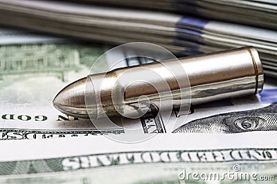 Close up of bullet laying on american dollars background Stock Photo
