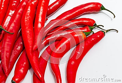 Close up of bunch of long red chili peppers on a white background isolated. It lies diagonally Stock Photo