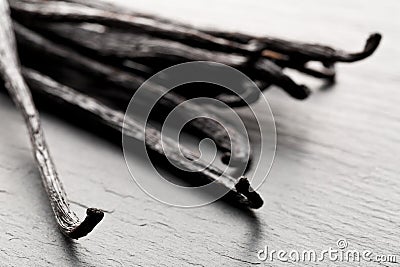 Close up of a bundle of dried bourbon vanilla beans or pods on black stone board Stock Photo