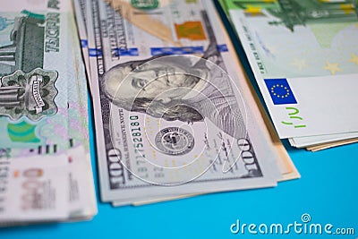 close up bundle of money Euros, dollars, rubles banknotes on the blue background, business, finance, saving, banking concept Stock Photo