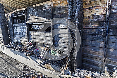 Close up Burned damaged ruins of destroyed supermarket metallic facade arson investigation insurance Stock Photo