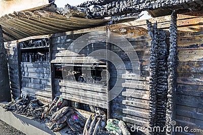 Close up Burned damaged ruins of destroyed supermarket metallic facade arson investigation insurance Stock Photo