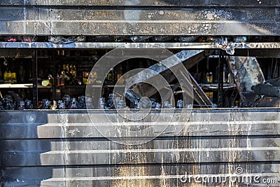 Close up Burned damaged ruins of destroyed supermarket metallic facade arson investigation insurance Stock Photo