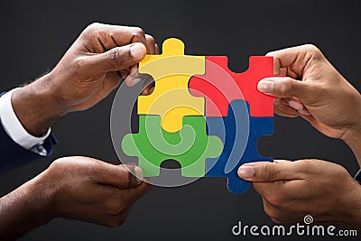 Hands Combining White Puzzle Pieces Stock Photo