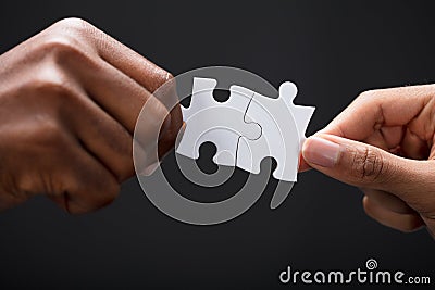 Hands Combining White Puzzle Pieces Stock Photo