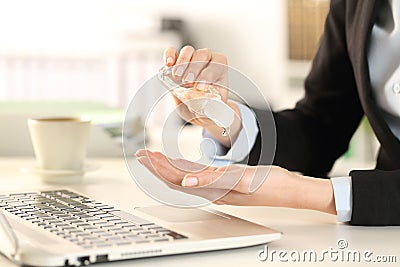 Business woman cleaning hands with sanitizer in the office Stock Photo