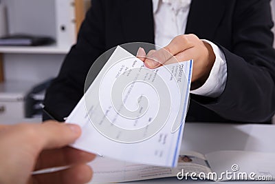 Business Woman Handing Over Cheque To Her Colleague Stock Photo