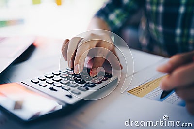 Close up of businessman or accountant working on calculator to calculate business data, and accountancy document. Business Stock Photo