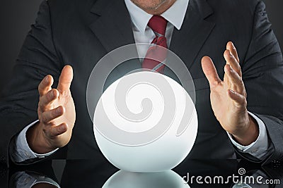 Close-up Of Businessman Hand On Crystal Ball Stock Photo