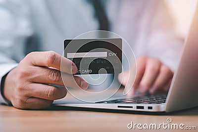 Close up of businessman hands holding a credit card and making a purchase using a laptop Stock Photo