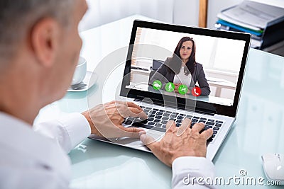 Businessman Videoconferencing With Colleague On Laptop Stock Photo