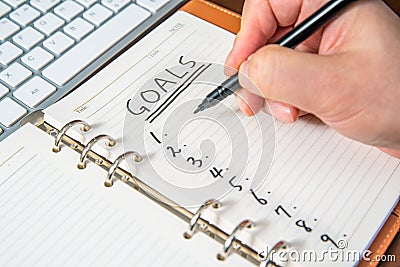 Close-up of a businessman`s hand writing goals and list in the diary Stock Photo