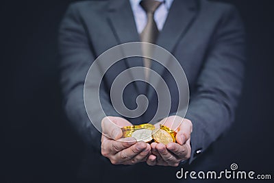 Close-up of businessman`s hands full of bitcoin sign of coins. Stock Photo