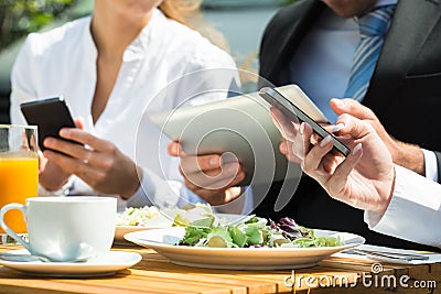 Close-up Of Businesspeople Using Digital Tablet And Mobile Phone Stock Photo