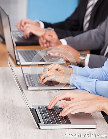 Close-up Of Businesspeople Using Laptop Stock Photo