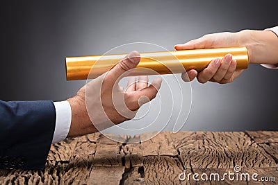 Close-up Of A Businessperson Passing Baton Stock Photo