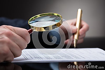 Businessperson Checking Contract Form Through Magnifying Glass Stock Photo