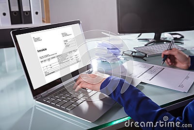 Businessperson Checking Invoice On Laptop Stock Photo