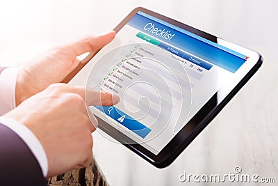 Businessperson Filling Checklist Form On Digital Tablet Stock Photo